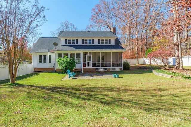 rear view of house with a sunroom and a lawn