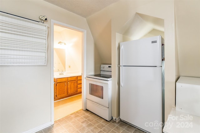 kitchen featuring sink, white appliances, and a textured ceiling