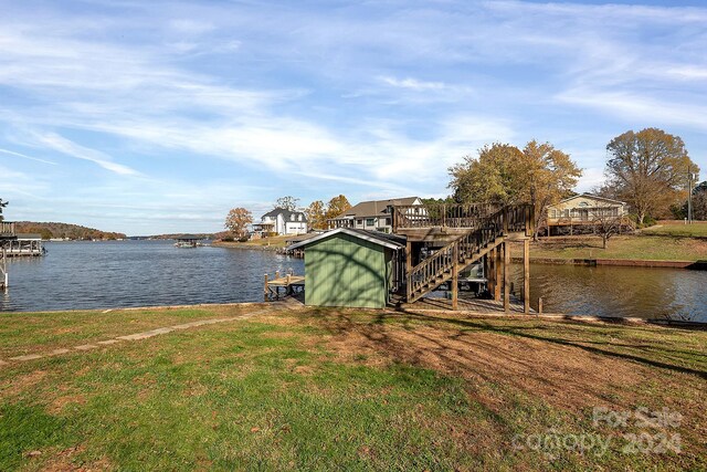 dock area with a deck with water view and a yard