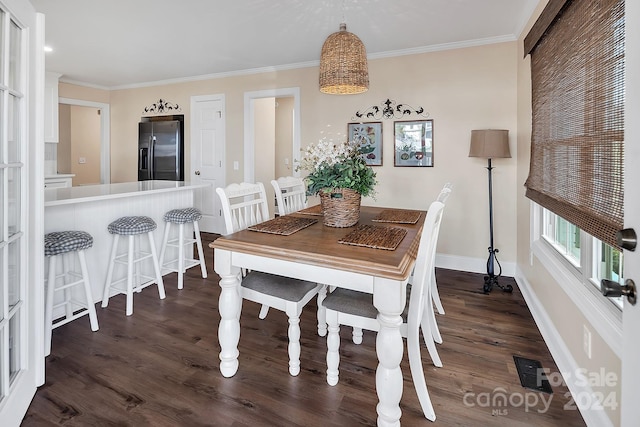 dining area featuring dark hardwood / wood-style floors and ornamental molding