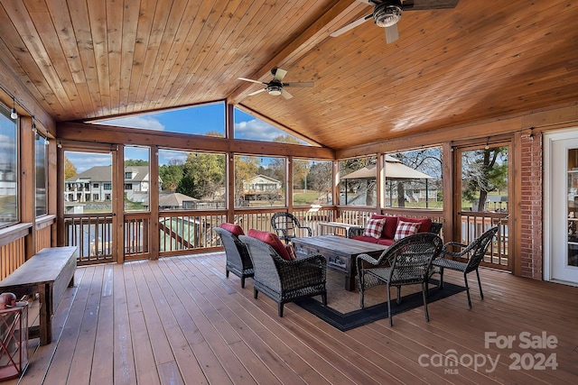 sunroom with lofted ceiling with beams, ceiling fan, and a healthy amount of sunlight