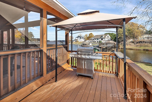 wooden terrace featuring a gazebo and a water view