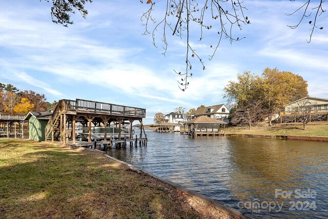 dock area with a water view and a yard