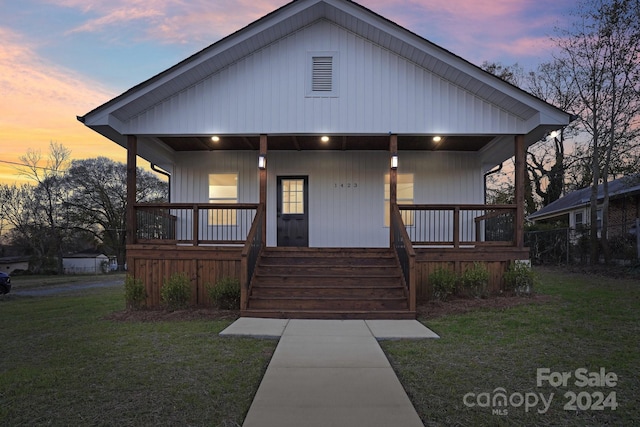 view of front of house with covered porch and a lawn