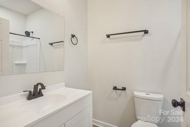 bathroom featuring walk in shower, vanity, and toilet