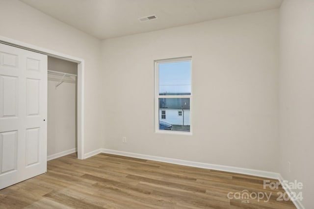 unfurnished bedroom featuring light wood-type flooring and a closet