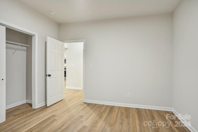 unfurnished bedroom with light hardwood / wood-style floors and a closet
