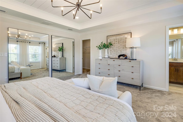 bedroom with ensuite bath, sink, a chandelier, light colored carpet, and a walk in closet