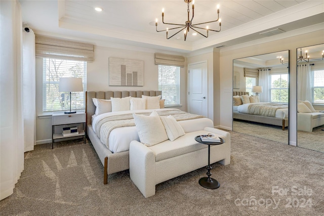 bedroom with carpet flooring, a raised ceiling, a notable chandelier, and crown molding