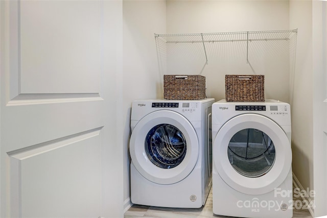 clothes washing area with light hardwood / wood-style flooring and washing machine and clothes dryer