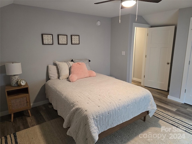 bedroom featuring ceiling fan, dark wood-type flooring, and lofted ceiling