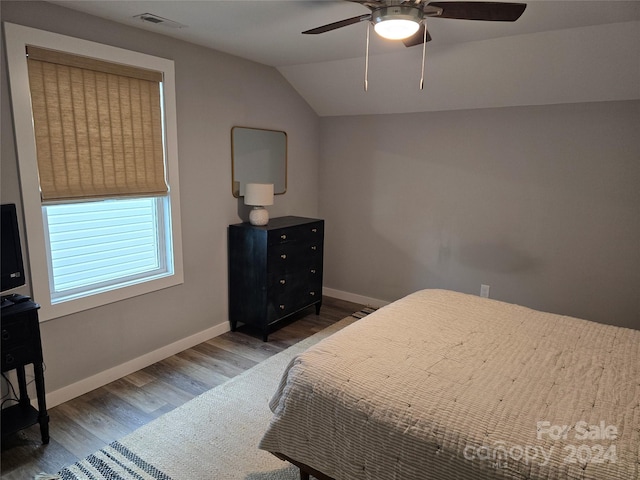 bedroom featuring dark hardwood / wood-style floors, ceiling fan, and vaulted ceiling