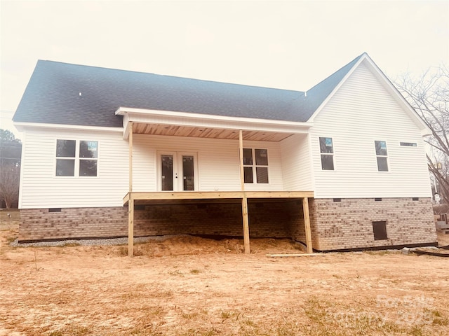 rear view of house with crawl space, french doors, and roof with shingles