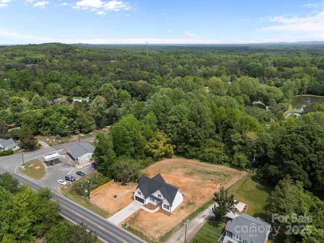 birds eye view of property featuring a view of trees