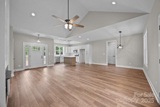 unfurnished living room with light wood-style floors, high vaulted ceiling, a ceiling fan, baseboards, and recessed lighting