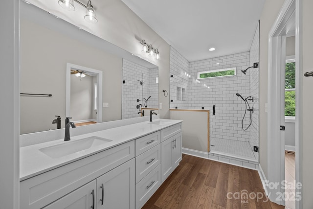 bathroom featuring a sink, tiled shower, and wood finished floors