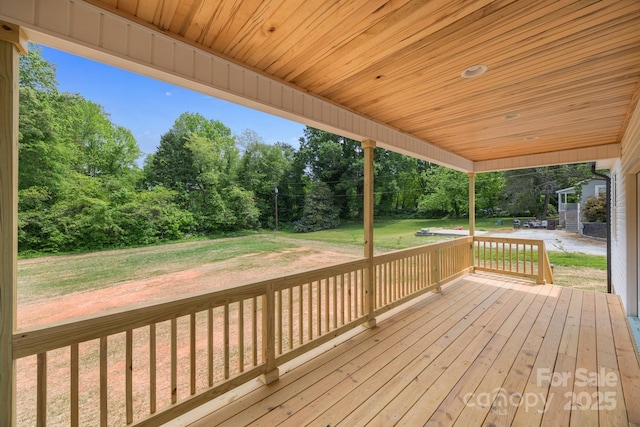 wooden terrace with a lawn