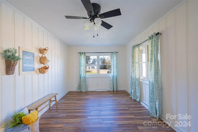 unfurnished room with ceiling fan, dark hardwood / wood-style flooring, ornamental molding, and a baseboard heating unit