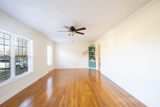 unfurnished room with ceiling fan, wood-type flooring, and ornamental molding