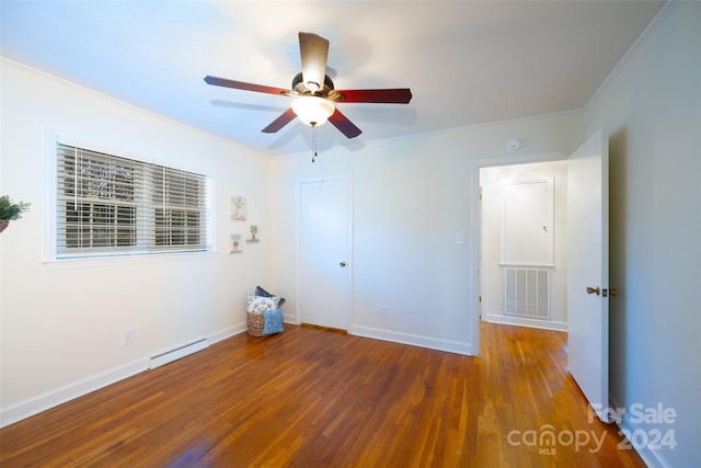 unfurnished bedroom with a baseboard heating unit, ceiling fan, dark hardwood / wood-style floors, and ornamental molding