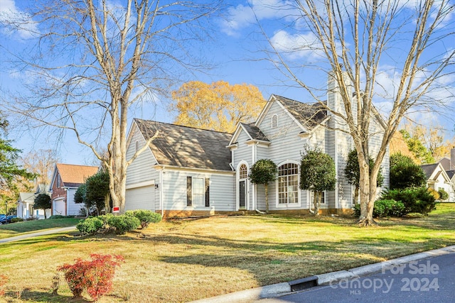 cape cod-style house featuring a front lawn and a garage