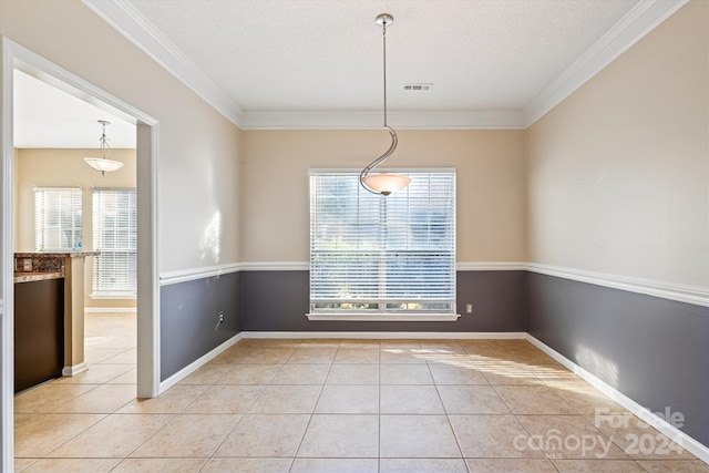 unfurnished dining area featuring tile patterned flooring, a textured ceiling, and ornamental molding