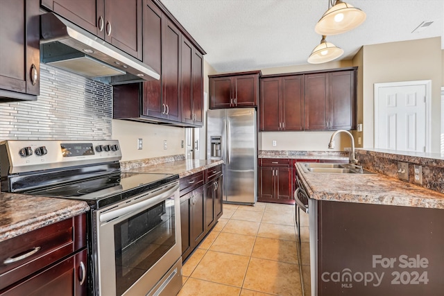 kitchen featuring sink, hanging light fixtures, stainless steel appliances, a textured ceiling, and light tile patterned floors