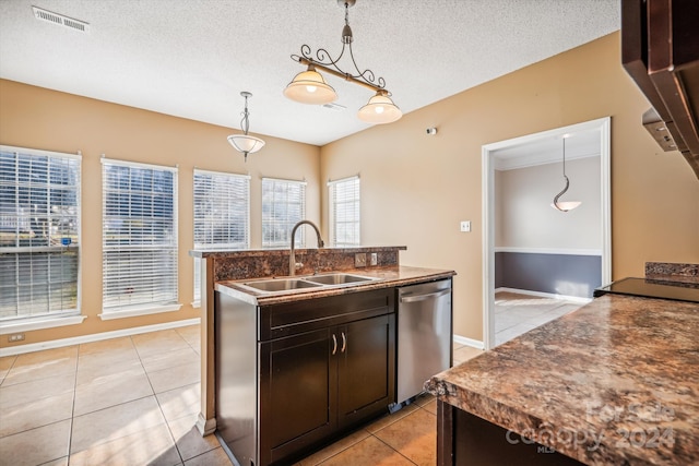 kitchen with dark brown cabinetry, sink, hanging light fixtures, stainless steel dishwasher, and a textured ceiling