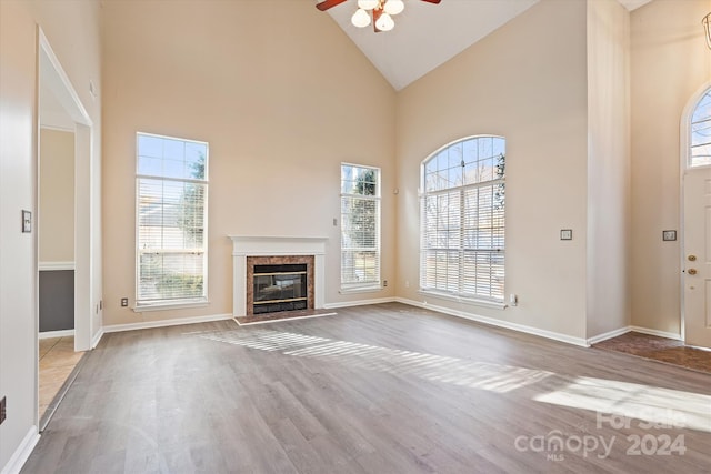 unfurnished living room featuring hardwood / wood-style floors, ceiling fan, and high vaulted ceiling