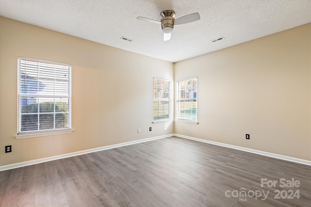 empty room with dark hardwood / wood-style floors, ceiling fan, and a textured ceiling