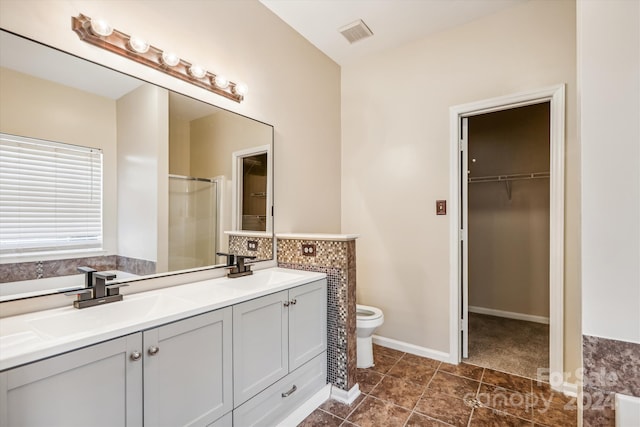 bathroom with tile patterned floors, vanity, toilet, and an enclosed shower