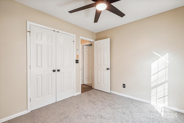 unfurnished bedroom with a closet, ceiling fan, and light colored carpet