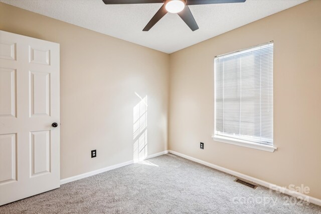 carpeted spare room featuring ceiling fan