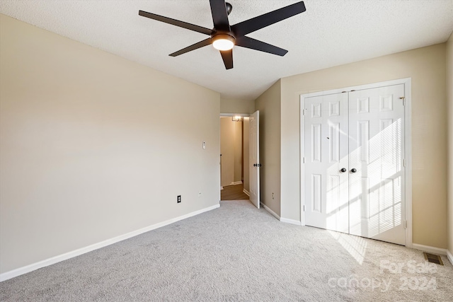 unfurnished bedroom featuring a closet, ceiling fan, and light colored carpet