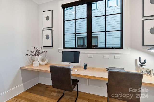 home office featuring wood-type flooring and built in desk