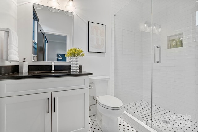 bathroom with tile patterned flooring, vanity, toilet, and walk in shower