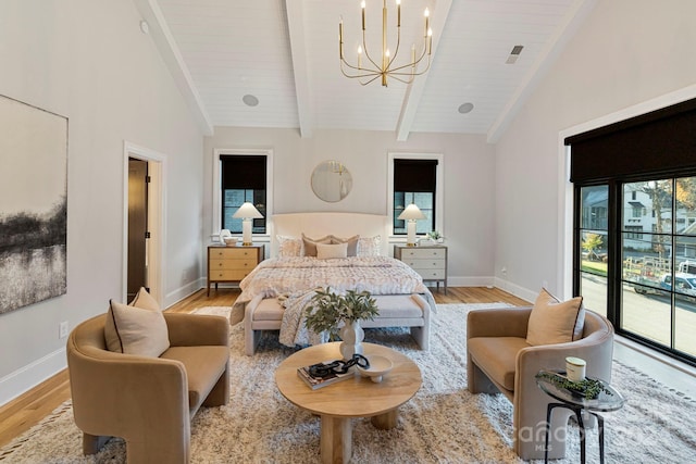 bedroom with access to exterior, beamed ceiling, light wood-type flooring, and a notable chandelier