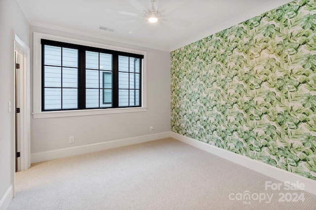 unfurnished room with carpet flooring, ceiling fan, and ornamental molding