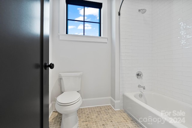 bathroom with tile patterned floors, tiled shower / bath, and toilet