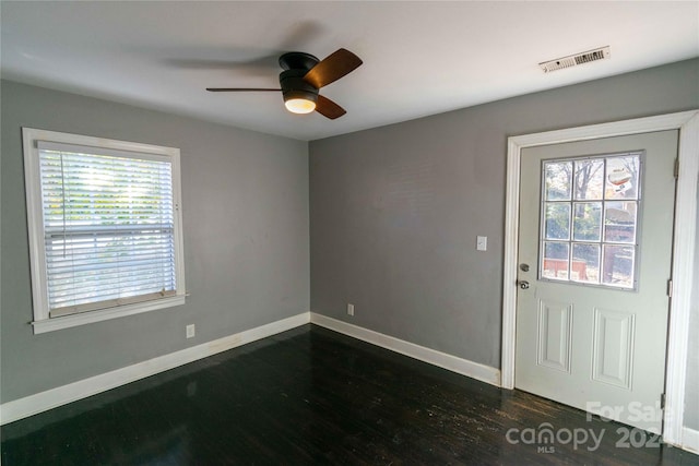 foyer entrance featuring ceiling fan, dark wood-type flooring, and a wealth of natural light