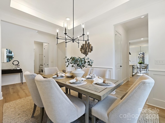 dining area with light wood-type flooring and a chandelier