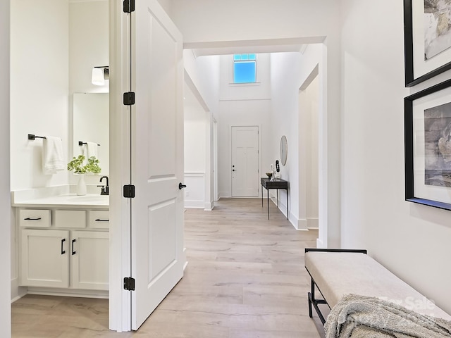 corridor featuring light hardwood / wood-style floors and sink