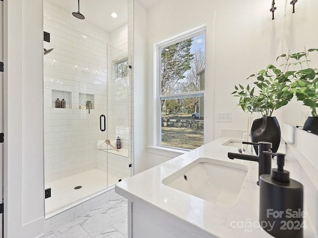 bathroom with a wealth of natural light, a shower with shower door, and sink