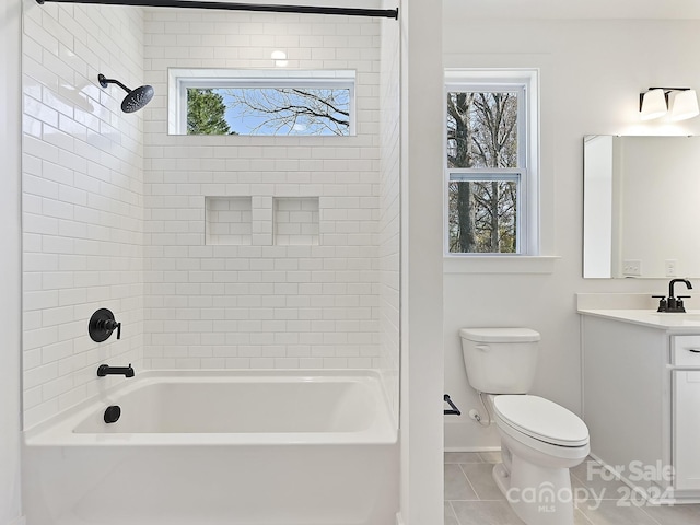 full bathroom featuring tile patterned floors, vanity, tiled shower / bath combo, and toilet