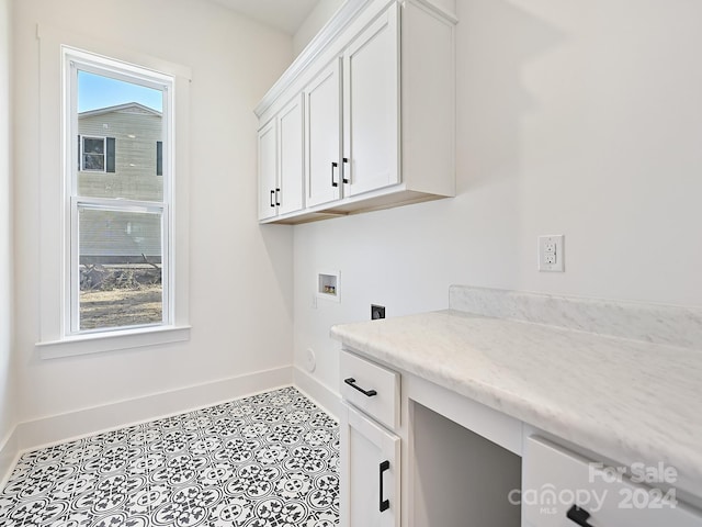 laundry area featuring cabinets, light tile patterned floors, and hookup for a washing machine