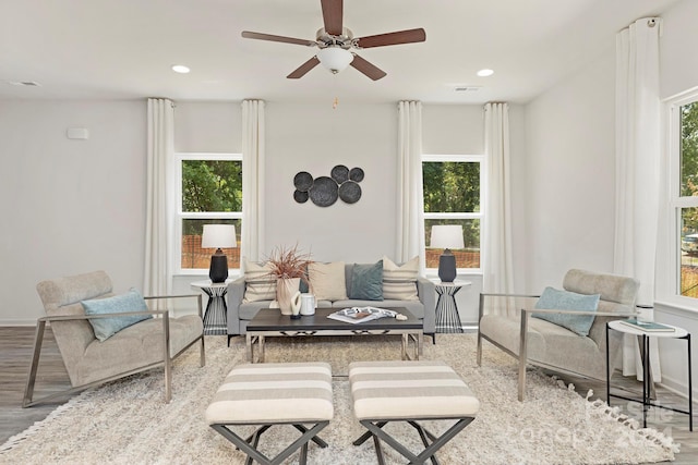 living area featuring wood-type flooring and ceiling fan