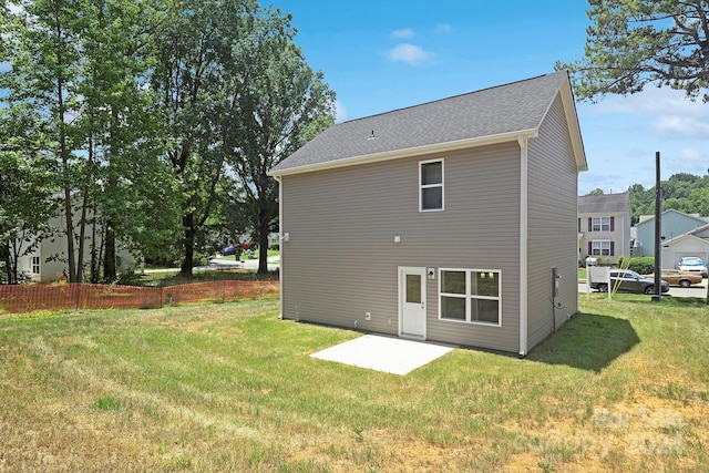 rear view of property featuring a lawn and a patio