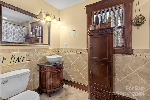 bathroom featuring a shower with shower curtain, vanity, toilet, and tile walls