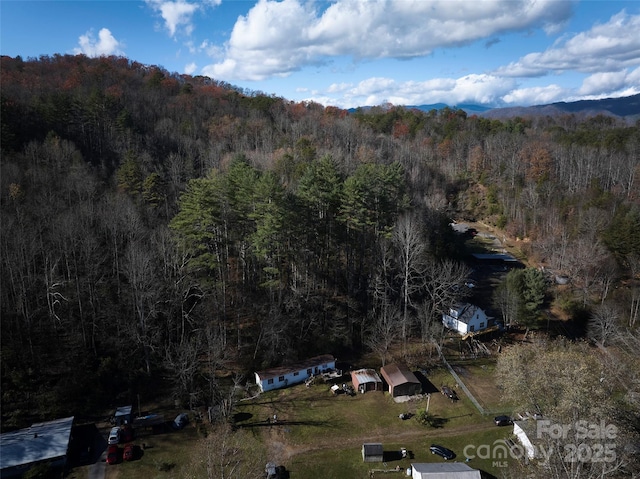 bird's eye view with a wooded view