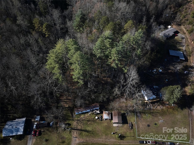 birds eye view of property featuring a view of trees